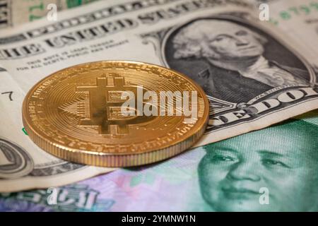 Berlin, Deutschland. November 2024. Eine goldene Bitcoin-Münze liegt auf Banknoten in verschiedenen Währungen. Quelle: Fernando Gutierrez-Juarez/dpa/Alamy Live News Stockfoto