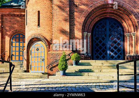 Die Fassade der katholischen Kirche hat Bogentüren, die mit Metall gepolstert sind. Hochwertige Fotos Stockfoto