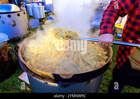 Traditionelles türkisches Pilaw wird in einem großen gusseisernen Kessel gekocht, während die Küche zubereitet wird Stockfoto