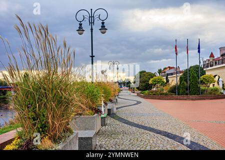 Ein Boulevard mit wunderschönen Blumenbeeten und Bäumen am Ufer des Flusses. Hochwertige Fotos Stockfoto