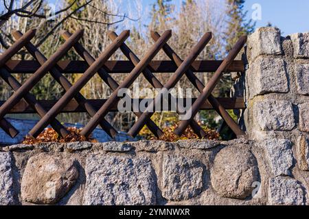 Der Zaun besteht aus Naturstein und überkreuzten Holzpfählen. Hochwertige Fotos Stockfoto