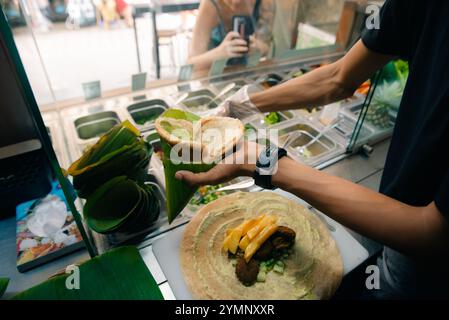 Der Koch bereitet am Straßenstand Pita-Brot für Falafelbrötchen im Freien zu Stockfoto