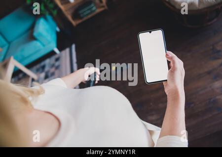 Zugeschnittenes Foto von Frau gekleidetes weißes Hemd, das Wochenende putzt und modernen Gadget-leeren Raum im Haus-Apartment-Zimmer hält Stockfoto