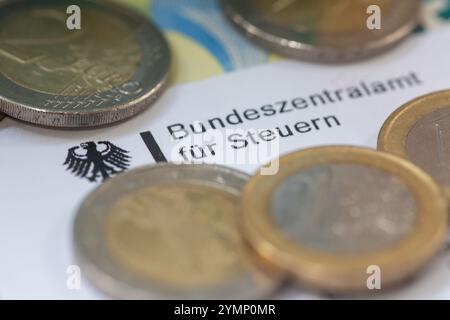 Berlin, Deutschland. November 2024. Münzen und Banknoten befinden sich auf einem Brief des Bundessteueramtes. Das Bundeszentrale Steueramt (BZSt) ist organisatorisch Teil des Bundesministeriums für Finanzen (BMF). Es ist eine Bundesoberbehörde, die dem BMF unterstellt ist und verschiedene Aufgaben im Bereich der Besteuerung wahrnimmt, wie die Verwaltung der Umsatzsteuer-Identifikationsnummern, die Abwicklung des automatisierten Informationsaustauschs und die Bearbeitung von Steuererstattungen. Quelle: Fernando Gutierrez-Juarez/dpa/Alamy Live News Stockfoto