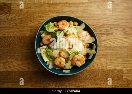Eine herzhafte Schüssel Shrimp Caesar Salat mit Garnelen, knusprigen Romaine Salat, knusprigen Croutons und dünn geschliffenem Parmesan Käse. Das Gericht wird serviert Stockfoto