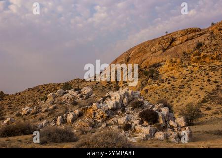 Ein großer felsischer Pegmatit, der im späten Nachmittagslicht zwischen den aus-Bergen im Naturschutzgebiet Rand in Namibia auftaucht. Stockfoto