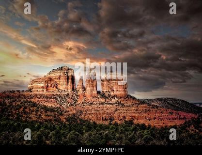 Die Golden Hour strahlt ein warmes Leuchten über Sedonas berühmten roten Felsen aus, während der Cathedral Rock majestätisch vor dem dunkleren Himmel steht. Stockfoto