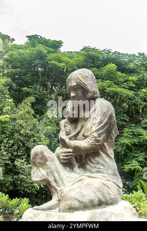 Geschnitzte Statue einer Frau, die ihr Kind in der Cheong Ek Killing Fields Gedenkstätte hält Stockfoto