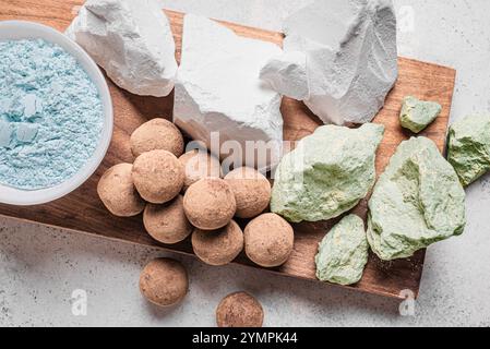 Essbare verschiedene Tonsteine, Tongesteine und Pulver auf hölzernem Hintergrund, Blick von oben. Natürlich essbare Kalziumkreide oder -Ton, trendiger Snack. Stockfoto
