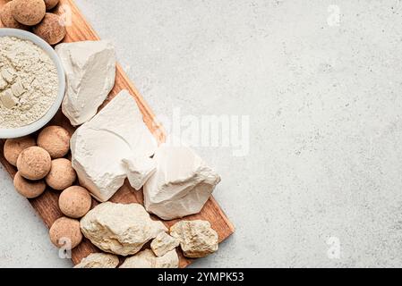 Essbare Karamell Ton Steine, Ton Felsen und Pulver auf weißem Stein Hintergrund, Draufsicht, Kopierraum. Natürliche genießbare Kalziumkreide und Tonkugeln für EA Stockfoto