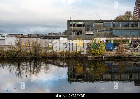 Häuser, verlassene Industrie und Boote reflektieren im westlichen Marktkanal in Amsterdam, Niederlande, 15. November 2024 Stockfoto