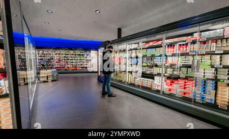 Hamburg, Deutschland. November 2024. Ein Kunde steht vor Kühlregalen mit Milchprodukten in einem Supermarkt. Quelle: Markus Scholz/dpa/Alamy Live News Stockfoto