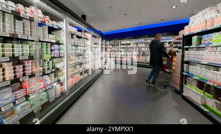 Hamburg, Deutschland. November 2024. Ein Kunde steht vor Kühlregalen mit Milchprodukten in einem Supermarkt. Quelle: Markus Scholz/dpa/Alamy Live News Stockfoto