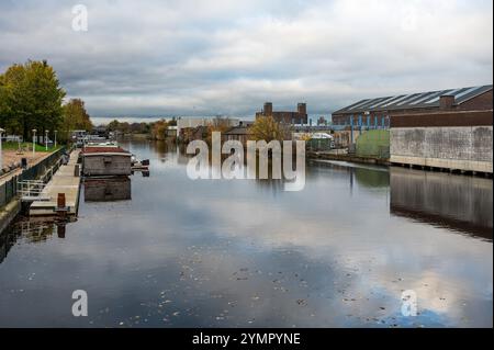 Häuser, verlassene Industrie und Boote reflektieren im westlichen Marktkanal in Amsterdam, Niederlande, 15. November 2024 Stockfoto