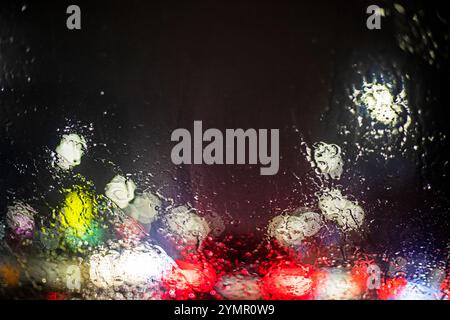 Lichtreflexionen einer Autoscheibe im Regen im Stau. Sicherheit im Straßenverkehr. Schlechte Sicht Stockfoto