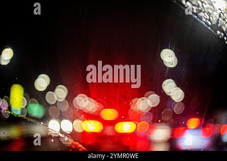 Lichtreflexionen einer Autoscheibe im Regen im Stau. Sicherheit im Straßenverkehr. Schlechte Sicht Stockfoto
