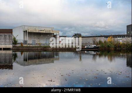 Häuser, verlassene Industrie und Boote reflektieren im westlichen Marktkanal in Amsterdam, Niederlande, 15. November 2024 Stockfoto