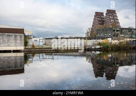 Häuser, verlassene Industrie und Boote reflektieren im westlichen Marktkanal in Amsterdam, Niederlande, 15. November 2024 Stockfoto