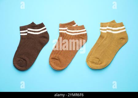 Verschiedene weiche Socken auf hellblauem Hintergrund, flach geschnitten Stockfoto