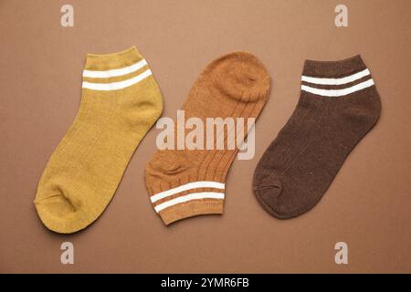 Verschiedene weiche Socken auf hellbraunem Hintergrund, flach geschnitten Stockfoto