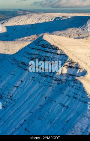 Sonnenlicht beleuchtet den schneebedeckten Gipfel von Cribyn in den Brecon Beacons, Wales Stockfoto