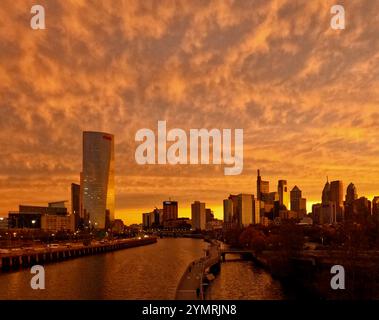 Der Sonnenaufgang beleuchtet die Wolken über der Skyline von Philadelphia, von der South Street Bridge aus gesehen. Stockfoto