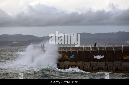 Victoria, British Columbia, Kanada, 22. November 2024 - Wellen, die von starken Winden aufgepeitscht werden, stürzen über Fußgänger und Jogger am Ogden Point Breakwater in Victoria, BC, Kanada, als sich ein herbstlicher Sturm Vancouver Island nähert. Don Denton/Alamy Live News Stockfoto