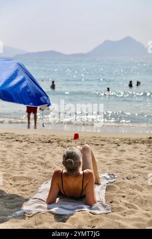 25. Juli 2022, Aegiali, Südägäis, Griechenland: Ein Tourist sonnt sich am Strand von Aegiali in Amorgos, Griechenland. Die griechische Insel Amorgos, eine ruhige Insel der Kykladen, die von den Fähren kaum bedient und bis Ende der 1980er Jahre vernachlässigt wurde, wurde ab 1988 bei Touristen sehr beliebt. Im selben Jahr erschien der französische Film The Big Blue (Le Grand Bleu) unter der Regie von Luc Besson. Er verkaufte 9,2 Millionen Tickets und wurde zum meistverkauften Film des Jahres an der französischen Kinokasse. Auf Amorgos gefilmt, gab es der Insel viel Publicity. 2021 besuchten 80.400 Touristen diese kleine Insel Stockfoto