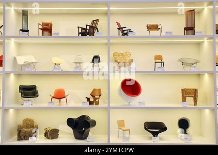 Miniaturen von Designerstühlen im Schaufenster des Vitra Museums weil am Rhein zeichnen die Geschichte des Designs nach. Von links nach rechts auf dem obersten Regal: Hill House 1 von Charles Rennie Mackintosh, Barrel Chair von Frank Lloyd Wright, Sitzmaschine von Josef Hoffmann, Rood blauwe stoel von Gerrit Rietveld, MR 20 von Mies van der Rohe, Robie 1 von Frank Lloyd Wright. Auf dem zweithöchsten Regal: La Chaise, RAR und DSW von Charles & Ray Eames, Gala von Albini, Standard Chair von Jean Prouvé und Diamond Chair von Harry Bertoia. Auf der zweitniedrigsten Schelfeile: Karuselli von Yrjö Kukkapuro, 3 Stockfoto