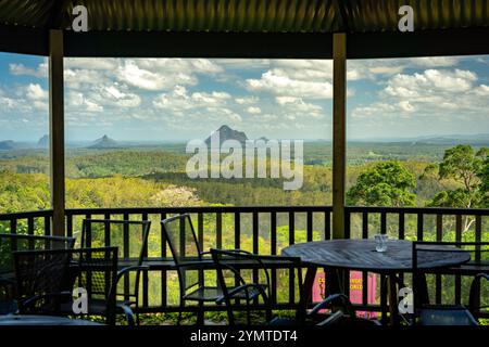 Maleny, QLD, Australien – Picknicktische in den Botanischen Gärten von Maleny mit den Bergen im Hintergrund des Glashauses Stockfoto