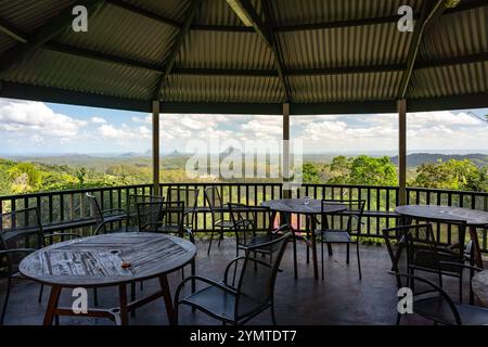 Maleny, QLD, Australien – Picknicktische in den Botanischen Gärten von Maleny mit den Bergen im Hintergrund des Glashauses Stockfoto