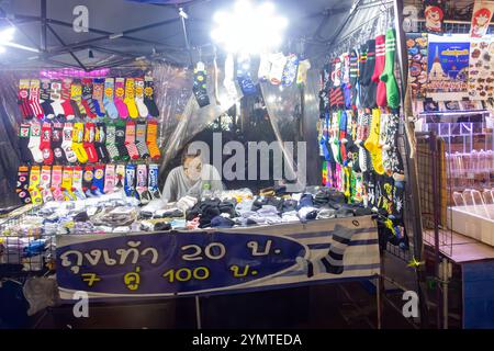 SAMUT PRAKAN, THAILAND, 26. Oktober 2024, Eine Frau verkauft Socken an einem Nachtmarkt-Kiosk Stockfoto