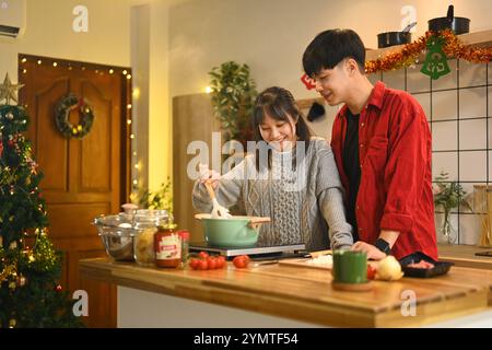 Wunderschönes junges Paar, das am Weihnachtsabend in der Küche Abendessen zubereitete Stockfoto