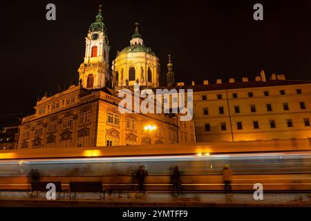 Nikolaikirche mit Straßenbahnen, die nachts vorbeifahren, Prag, Tschechien Stockfoto