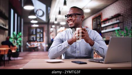 Geschäftsmann Genießt Kaffeegetränk Im Luxuscafé Mit Laptop Und Lächelndem Lächeln Stockfoto