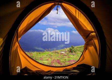 Fantastischer Blick am Morgen von einem Campingzelt auf die Bergkette mit blauem bewölktem Himmel Stockfoto
