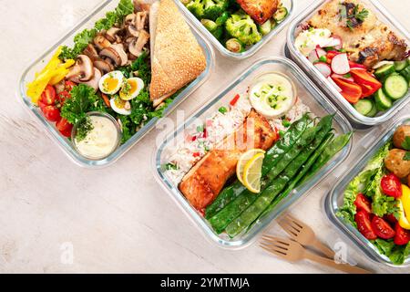 Verschiedene köstliche gesunde Mahlzeiten in Behältern auf weißem Hintergrund, Draufsicht. Stockfoto