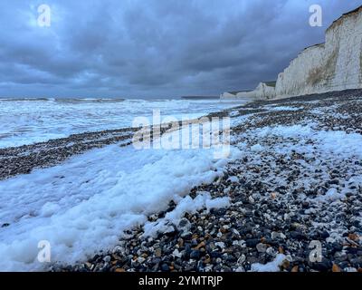 Birling Gap, Eastbourne. November 2024. Sturmwind, große Wellen und treibender Regen trafen heute Morgen die Südküste, als Sturm Bert an Land kam. Das Met Office hat heute von 15 bis 21 Uhr eine gelbe Wetterwarnung für die Südküste ausgegeben, da sich der Sturm Bert intensivieren wird. Große Wellen erzeugten Seeschaum bei Birling Gap in Eastbourne in East Sussex. Das Gelände gehört dem National Trust, der befürchtet, dass der jüngste benannte Sturm zu weiteren Einstürzen der Kreidefelsen führen könnte, wie er am 23. Oktober 2024 zu sehen war, als ein großer Teil der Klippe auf den Strand fiel. Besucher sind Werbung Stockfoto