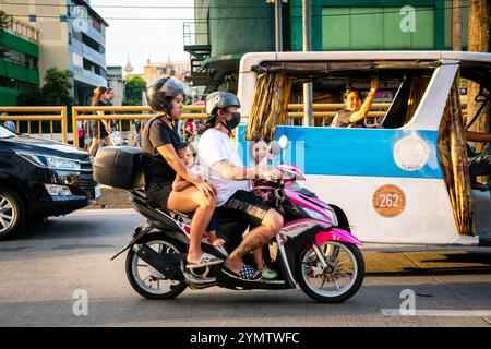 Eine junge philippinische Familie reist mit einem Motorrad durch die geschäftigen Straßen der China Town Gegend von Manila. Die Philippinen. Stockfoto