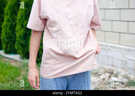 Die Frau trug ein gerolltes T-Shirt. Stockfoto