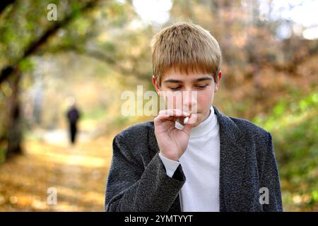 Problematischer Teenager, der im Park Zigarette raucht Stockfoto