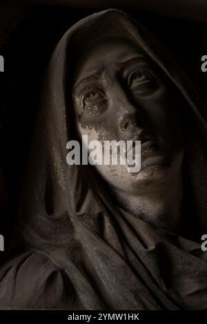 Details zu wunderschönen Skulpturen, Denkmälern und Grabsteinen in einer Galerie des Friedhofs Monumental in Mailand (Cimitero Monumentale di Milano). Stockfoto