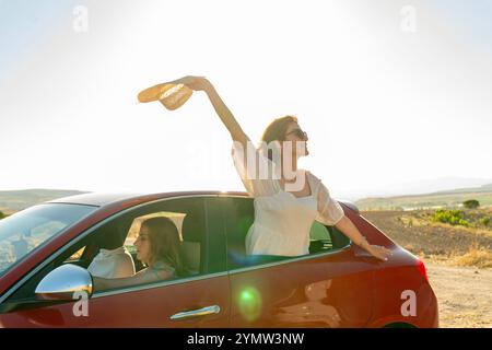 Zwei glückliche Freundinnen, die im Sommer mit dem Auto unterwegs sind. Stockfoto