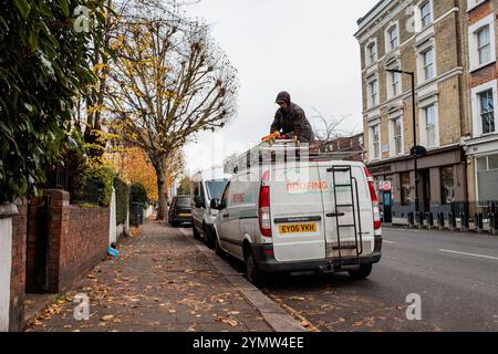 London, Großbritannien. November 2024. Ein Dachdecker sichert eine Leiter an einem geparkten Fahrzeug in Notting Hill. Quelle: Mark Kerrison/Alamy Live News Stockfoto