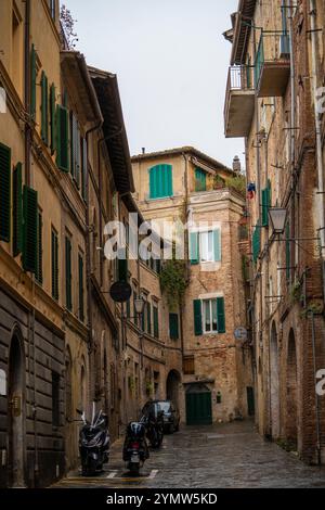 Blick auf die enge und gemütliche Straße in der Altstadt von Siena in Italien. Konzept der antiken Architektur der toskanischen Region. Siena, Italien 07.01.2024 Stockfoto