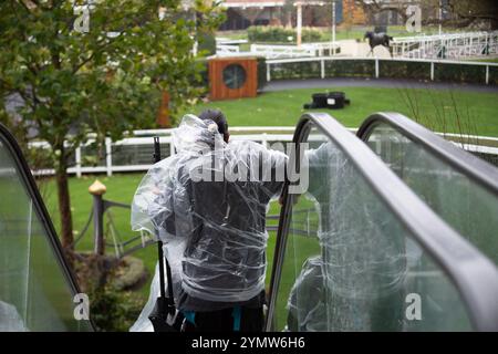 Ascot, Berkshire, Großbritannien. November 2024. Racegoer kämpften bei starkem Wind und Regen, als Storm Bert durch Großbritannien zieht, um ihre Regenschirme auf der Ascot Racecourse in Berkshire zu befestigen. Quelle: Maureen McLean/Alamy Live News Stockfoto