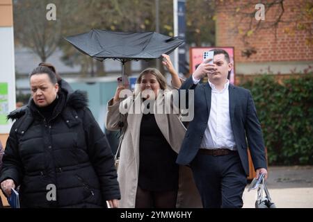 Ascot, Berkshire, Großbritannien. November 2024. Racegoer kämpften bei starkem Wind und Regen, als Storm Bert durch Großbritannien zieht, um ihre Regenschirme auf der Ascot Racecourse in Berkshire zu befestigen. Quelle: Maureen McLean/Alamy Live News Stockfoto