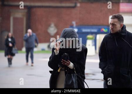 Ascot, Berkshire, Großbritannien. November 2024. Racegoer kämpften bei starkem Wind und Regen, als Storm Bert durch Großbritannien zieht, um ihre Regenschirme auf der Ascot Racecourse in Berkshire zu befestigen. Quelle: Maureen McLean/Alamy Live News Stockfoto