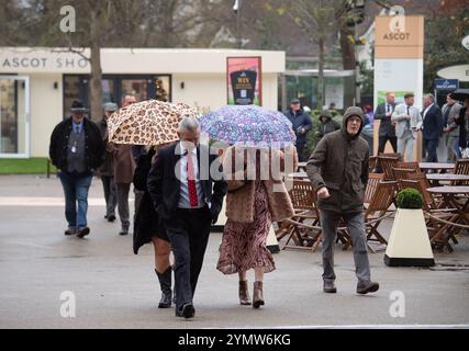 Ascot, Berkshire, Großbritannien. November 2024. Racegoer kämpften bei starkem Wind und Regen, als Storm Bert durch Großbritannien zieht, um ihre Regenschirme auf der Ascot Racecourse in Berkshire zu befestigen. Quelle: Maureen McLean/Alamy Live News Stockfoto