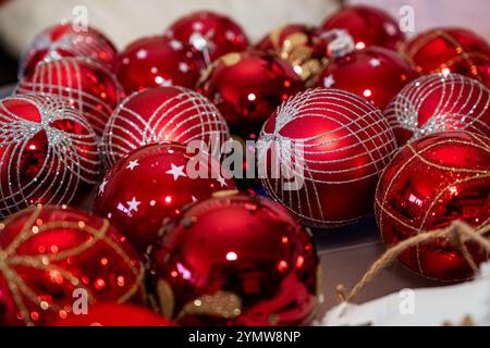 Ein Haufen roter und silberner Weihnachtsschmuck. Die roten sind der Hauptfokus des Bildes Stockfoto